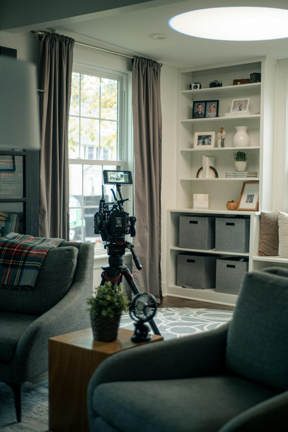 Bir oturma odasında tripod üzerinde video kamera.